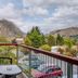Shotover Lodge in Queenstown balcony with chair, table, and mountain views over the landscaped grounds