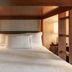The Flat Iron Hotel in Asheville: cozy wood-framed bed with bedside lamps and white bedding