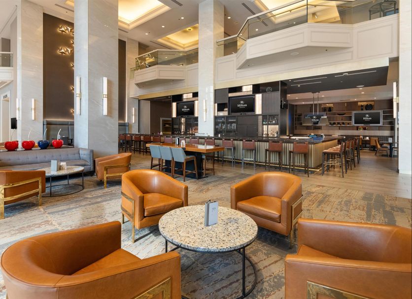 Hilton Minneapolis lobby with leather chairs, marble tables, and a spacious atrium lounge