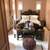 Riad Miral in Marrakech guest room with carved bed, low table, poufs, and ornate windows