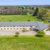 Lakewood Inn & Suites in Dowagiac, aerial view of a long two-story hotel beside a grassy field and trees