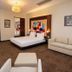 The Landmark Hotel Baku guest room with king bed, sofa, and city-view balcony