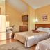 Hotel Stella di Mare in Bečići: twin beds in a warm guest room with wall art and bedside lamps