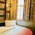 New Style Guest House in Hong Kong room with bed, TV, air conditioner, and patterned wallpaper