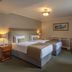 Bracken Court Hotel Balbriggan twin bedroom with two beds, lamps, dresser and window seating