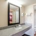 Bathroom at OYO Hotel Mcallen Airport South in McAllen with granite vanity, mirror, toilet and tub-shower