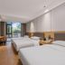 Tizi Hostel in Shanghai twin guest room with three beds, desk, wall-mounted TV, and balcony view