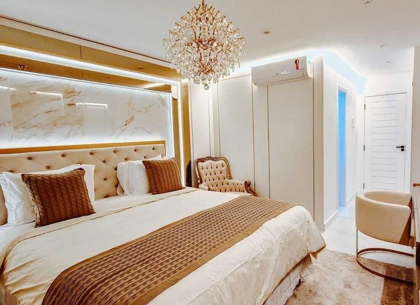 Azeda Boutique Hotel in Búzios, elegant bedroom with chandelier, tufted headboard and upholstered chair