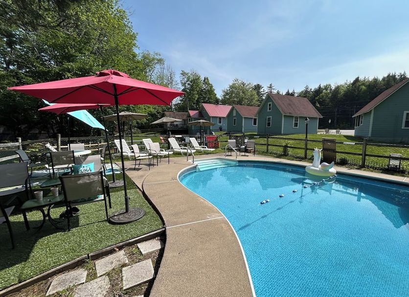White Mountain Motel And Cottages in Lincoln: outdoor pool with lounge chairs and cottages