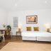 Cove Studios in Byron Bay room with bed, sofa, small dining table and wood flooring