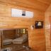 Fire pansiyon in Cirali room with wood-paneled walls, wall-mounted TV, air conditioner, and mirror