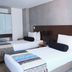 Hotel DC Feria Bogotá guest room with two twin beds and mirrored wall