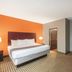 La Quinta Inn & Suites by Wyndham Houston Bush Intl Airpt E room with king bed and adjoining seating area in Humble