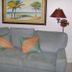 Islander Beach Resort New Smyrna Beach living room with gray sofa, tropical art and wall lamps