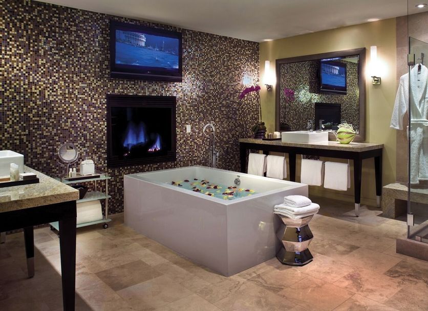 Sunset Marquis West Hollywood spa suite with soaking tub, fireplace, vanity and wall-mounted TV