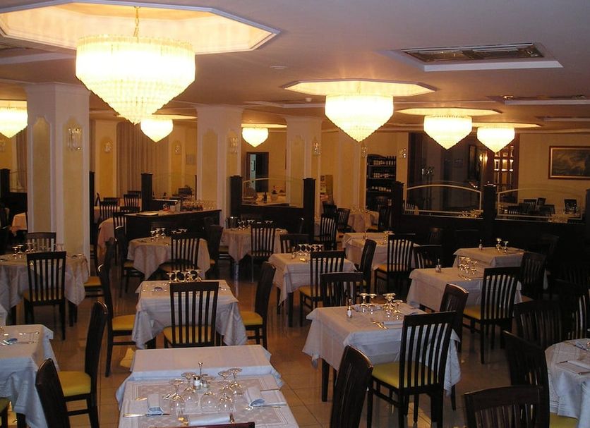 Valdenza in Campegine dining room with set tables, black chairs, and warm ceiling lights