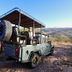 River Crossing Lodge Windhoek safari vehicle on a scenic hillside with mountain views