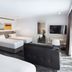 Mercure Sydney Blacktown room with three beds, wall-mounted TV and mirror in Blacktown