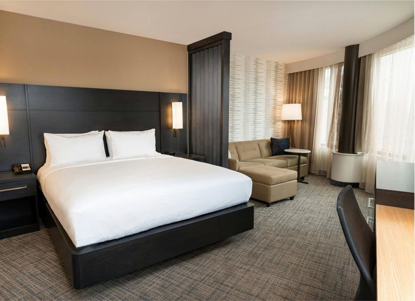 Residence Inn by Marriott Grand Rapids Downtown guest room with king bed, chaise lounge and city-view windows