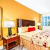 Mizner Place at Weston Town Center guest room with king bed, bedside lamps, TV, and window in Weston
