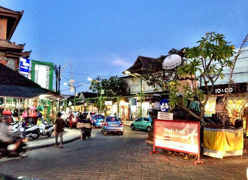 Bemo Corner Guest House in Kuta with a lively street view at dusk
