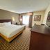 Sonesta Essential Hotels Overland Park guest room with king bed, window seat, and dresser