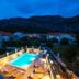 Apartments Azzurro in Dubrovnik with lit outdoor pool and mountain backdrop at dusk