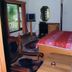 Himgiri Resorts in Dharamshala guest room with bed, TV, chairs, and balcony door