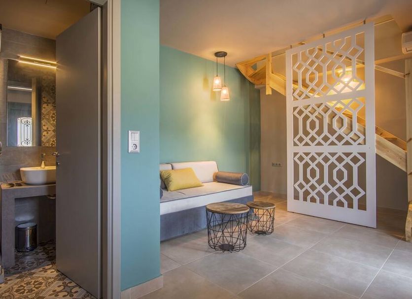 Armeno Resort in Marathias features a teal sitting area, bathroom nook and geometric staircase screen.