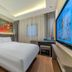 East Queen Hotel Lanzhou Taohai Branch room with king bed, desk, wall art and large TV in Lanzhou