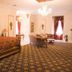 Dansereau House in Thibodaux: ornate guest room with carved bed, sofa, chandelier and patterned carpet