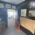 Lottin Point Motel in Hicks Bay, hallway with coastal paintings and doorway to a dining area