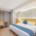 Aishangyijia Hotel Wuhu room with double bed, blue runner, desk, chair and curtained window