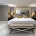 Mercure Istanbul Bomonti guest room with king bed, bench, mirrored wall and bedside lamps in Istanbul