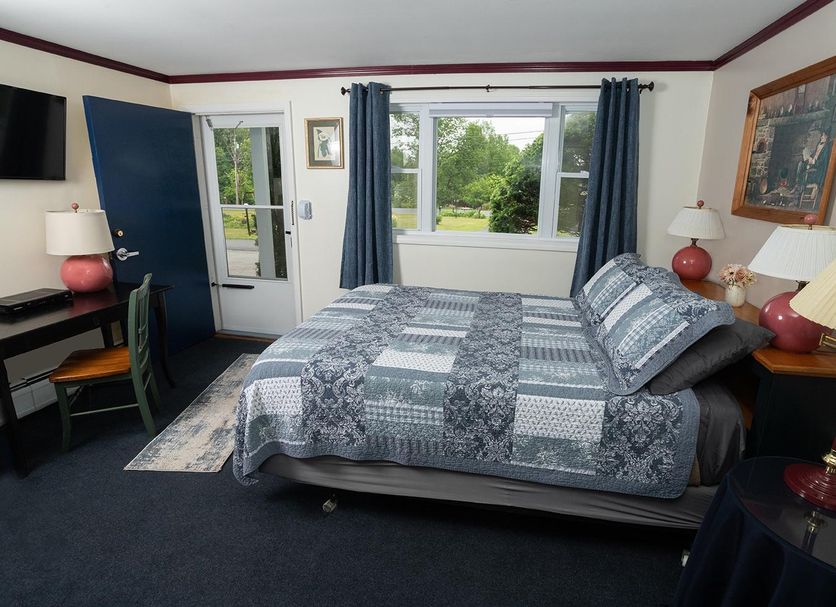Governor's Rock Motel room in Shaftsbury with queen bed, desk, TV, and window view of greenery