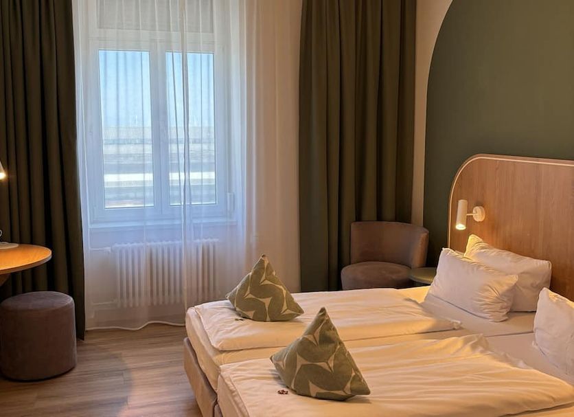 Gastehaus Centro, Konstanz guest room with twin beds, window view, desk, and seating area