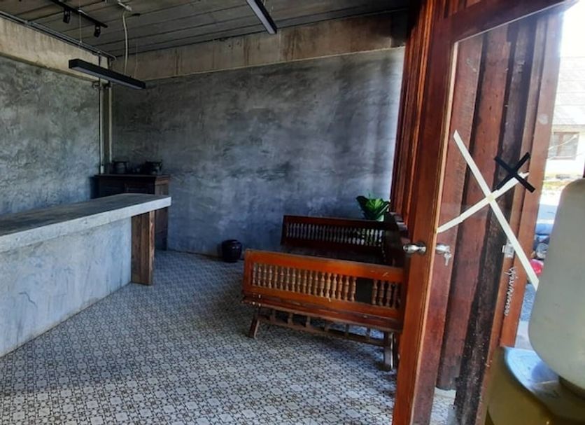 Pai Mountain Blues Cottage in Pai: rustic concrete bar area with woven seating and open doorway