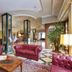Borgo Palace Hotel in Sansepolcro lobby with red leather sofas, patterned tile floor, and glass columns
