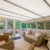 Crossbasket Castle, Glasgow conservatory lounge with wicker chairs, sofa and garden views