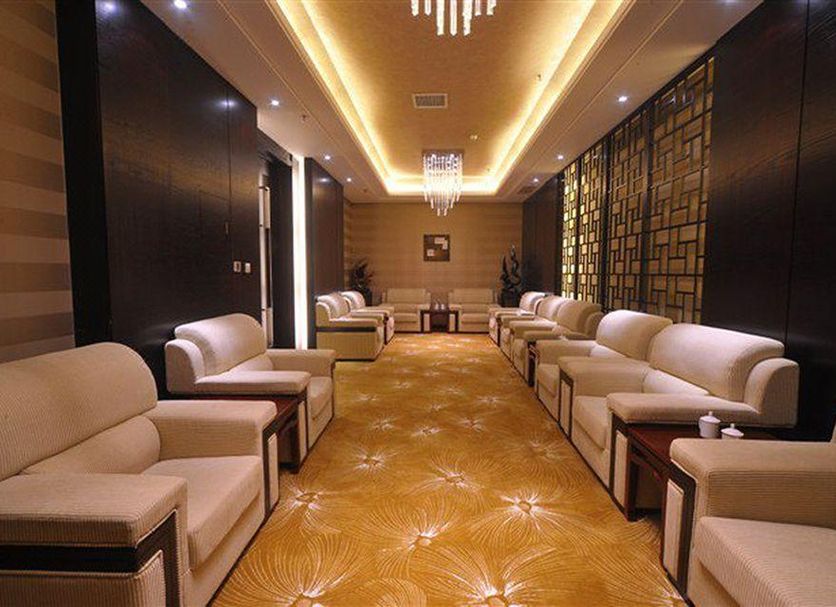 Tian Xing Hotel Chongqing lounge with beige armchairs, patterned carpet, and chandelier lighting