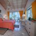 Stella Maris Resort Club guest room with ocean-view balcony, coral bedspread and orange curtains in Stella Maris