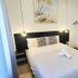 AYZ Javier Cabrini - Auto check-in property room in Madrid with double bed, hanging lights and wall art