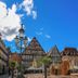 Hotel Pelikan in Schwäbisch Gmünd with historic half-timbered buildings and a church tower over a sunny plaza