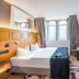 Seetelhotel Ostseehotel Ahlbeck room in Heringsdorf with king bed, TV, desk and arched window