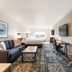 Four Points by Sheraton Elkhart guest room with king bed, sofa, desk, TV, and patterned carpet