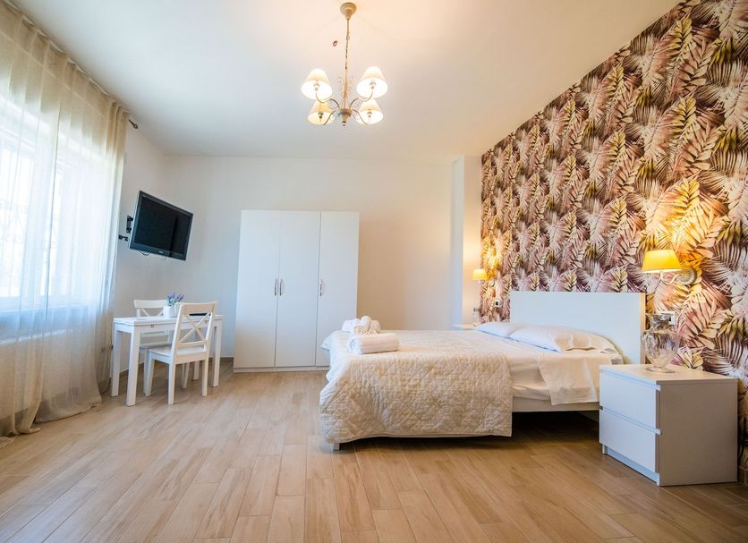 Residence O'Sole Mio Pompei room in Pompei with bed, desk, wardrobe and floral accent wall