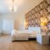 Residence O'Sole Mio Pompei room in Pompei with bed, desk, wardrobe and floral accent wall