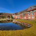 Muthu Ben Doran Hotel in Crianlarich with a pond reflecting the hotel and hillside scenery