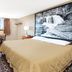 Super 8 by Wyndham Miles City guest room with desk, TV, window and waterfall wall art