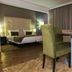 Hotel Santiago in Praia: guest room with bed, dining table and chairs, and floor-to-ceiling curtains